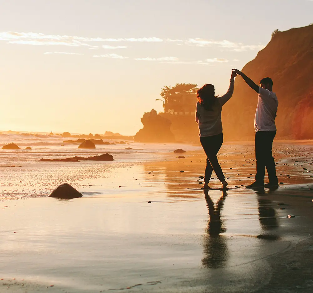 Pareja disfrutando de la playa al atardecer